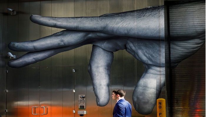 An optical illusion is created as a man walks past street art in New York. Photo: JUSTIN LANE