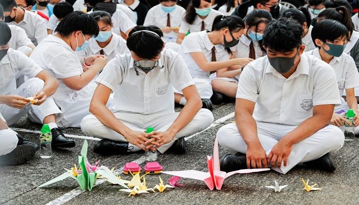 Schoolmates of a student protester who was shot by a policeman on Tuesday sit beside paper cranes while participating in a student gathering at Tsuen Wan Public Ho Chuen Yiu Memorial College in solidarity with the student in Tsuen Wan, Hong Kong, China, October 2, 2019. Photo: Reuters
