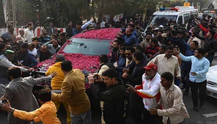 Supporters of Pakistan Muslim League Nawaz (PML-N) gather around a vehicle, covered with rose petals, carrying the ailing former Pakistani prime minister Nawaz Sharif as he travels to Lahore airport prior to his departure for abroad for medical treatment, in Lahore on November 19, 2019. Photo: AFP