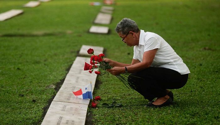 A woman places flowers on the grave of a person who died during the 1989 US military invasion that removed Panamanian strongman Manuel Noriega, on the 30th anniversary of the invasion in Panama City. According to official figures, 300 Panamanian soldiers and 214 civilians died during the invasion, though the number remains controversial and human rights groups believe it is much higher, while 23 US soldiers also perished. Photo: ARNULFO FRANCO/AP 