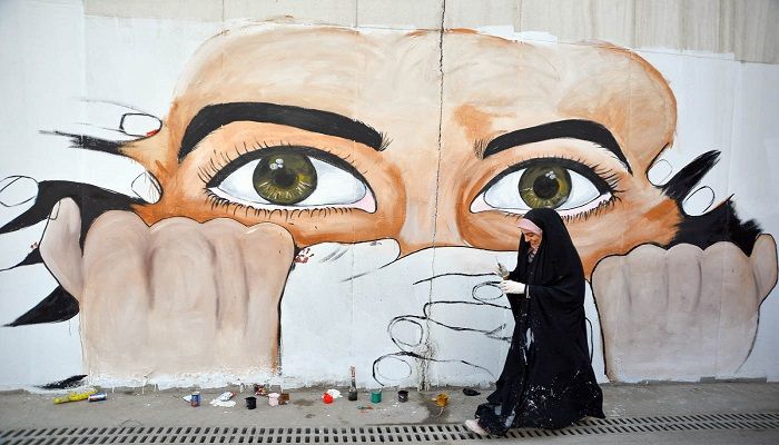 An Iraqi protester puts the final touches on a mural painting amid ongoing anti-government demonstrations in the central city of Najaf. Photo: HAIDAR HANDANI/AFP