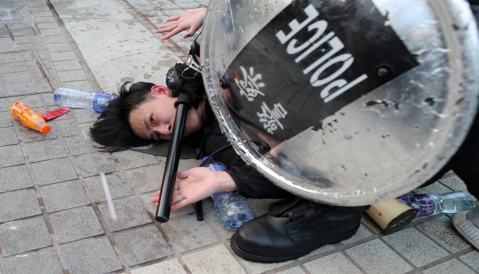 Police arrest a Hong Kong protester after a Chinese flag was removed from a flag pole at a rally in support of Xinjiang Uighurs' human rights in Hong Kong, China. Photo: LUCY NICHOLSON/REUTERS