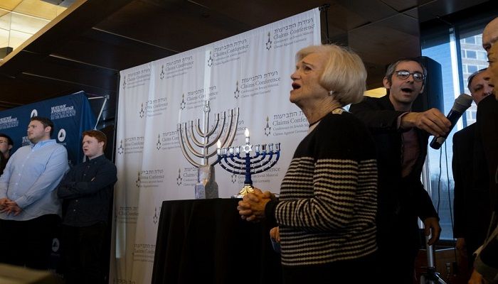 As a menorah is lighted, symbolizing the first day of Hanukkah, survivors of the Holocaust and other participants gather at the Museum of Jewish Heritage in New York Sunday, Dec. 22, 2019, to recognize International Holocaust Survivors Night, one of several events held around the world. The event was held in conjunction with the Conference on Jewish Material Claims Against Germany (Claims Conference), developed to aid Jewish victims of Nazism. Photo: AP