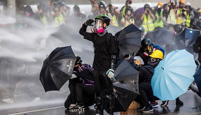 The continuous movement to demand democracy In Hong Kong. Anti-government protesters tried to escape the gas by weaving an umbrella and masks at the Central Government Complex on September 9. Photo: AFP