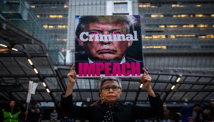 Connie Jeung-Mills of San Francisco holds a sign during a demonstration as part of a national impeachment rally at the Federal Building in San Francisco, California. Photo: PHILIP PACHECO/AFP