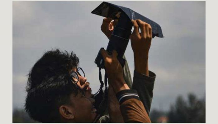 Two friends are watching the solar eclipse in Indonesia's Banda Aceh province. Photo: AFP