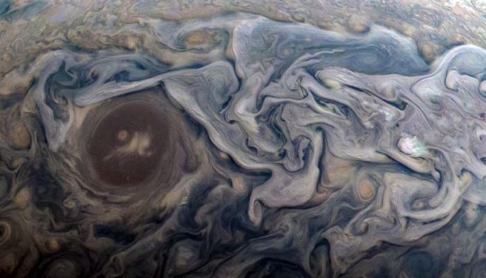 Up in the clouds: At the time, Juno was making a close pass of the fifth world from the Sun, approaching to between 18,600km (11,600 miles) and 8,600km (5,400 miles) of the swirling cloud tops. The image above shows swirling clouds that surround a circular feature within a jet stream region on Jupiter.