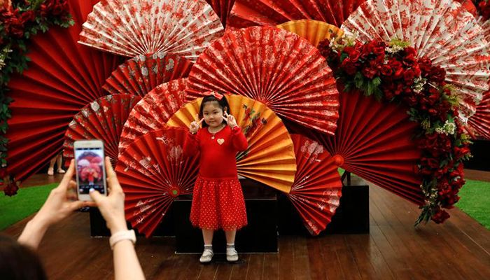 A girl poses for pictures near Lunar New Year decoration at a shopping mall in Jakarta, Indonesia, January 24, 2020. Photo: Reuters
