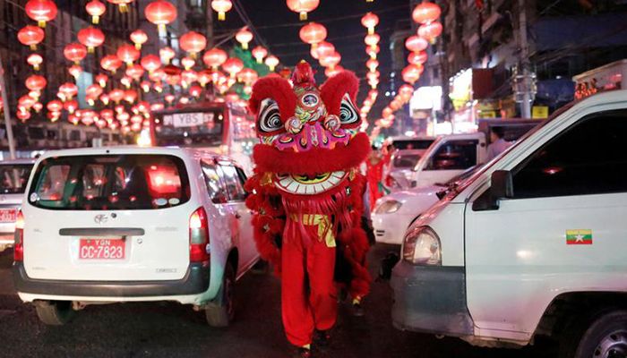 Members from a lion dance crew make their way through traffic as the greet people on the streets ahead of Chinese New Year in Yangon, Myanmar, January 20, 2020. Photo: Reuters