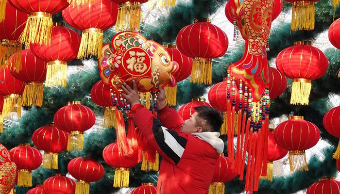 A staff member hangs decoration for a lantern arch at a park ahead of the Chinese Lunar New Year celebrations in Beijing, China January 19, 2020. Photo: China Daily via Reuters