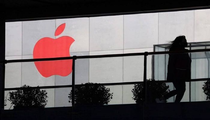 A woman runs past a Apple logo colored red in Beijing, China. Photo: Collected from AP