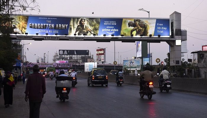 Commuters drive along a road past a billboard in Mumbai advertising the Amazon Prime Video online series "The Forgotten Army". Photo: Collected from AFP