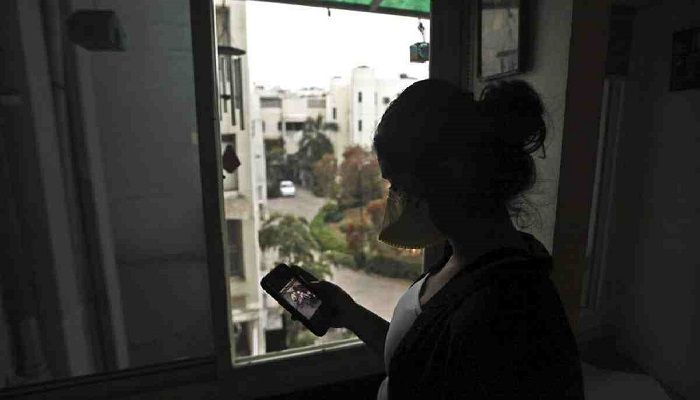 An Indian girl wearing a face mask as a precaution from coronavirus watches a video on the WhatsApp app in New Delhi, India. Photo: Collected from AP 