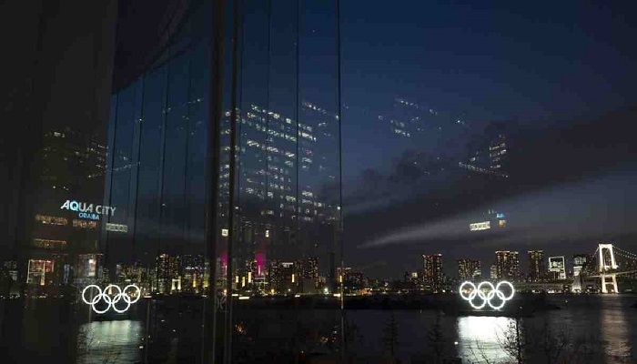 The Olympic rings are reflected in the glass wall of a wedding chapel in the Odaiba section of Tokyo, Monday, March 23, 2020. Photo: Collected from AP