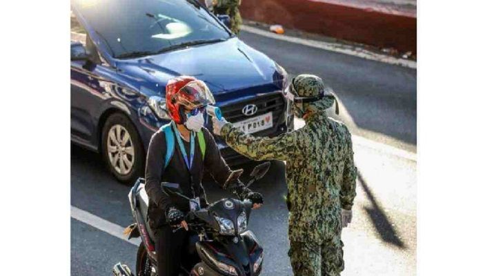 A policeman from the Philippine National Police (PNP) checks the body temperature of a motorist at a checkpoint in Manila, the Philippines, April 24, 2020. Photo: Collected from Xinhua
