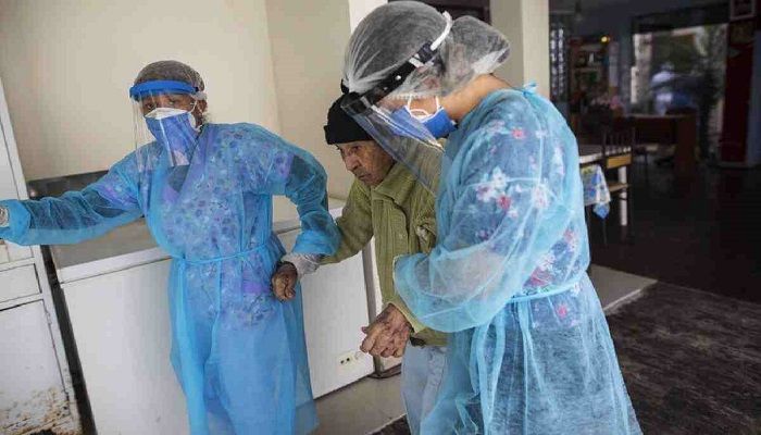 Nurses wearing protective gear walk with an elderly woman at the Mas Vida home for senior citizens, in Lima, Peru. Photo: Collected from AP 