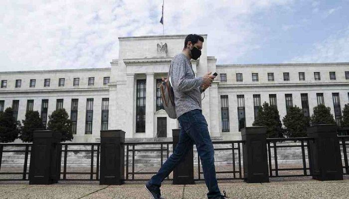 A man wearing a mask walks past the U.S. Federal Reserve building in Washington D.C., the United States. Photo: Collected from Xinhua 