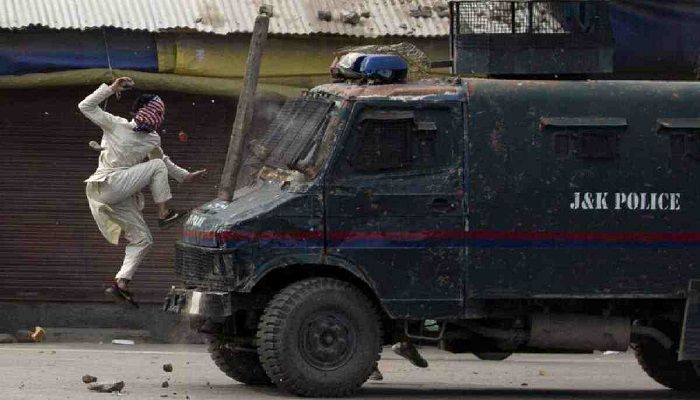 A masked Kashmiri protester jumps over an armored Indian police vehicle as he throw stones at it during a protest in Srinagar, Indian controlled Kashmir, May 31, 2019. Photo: Collected from AP