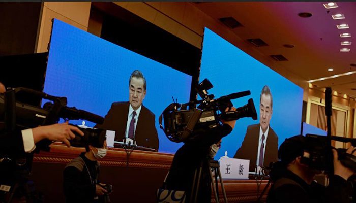Chinese State Councillor and Foreign Minister Wang Yi is displayed on screens as he attends via video link a news conference on the sidelines of the National People's Congress (NPC), in Beijing, China March 7, 2021. Photo: Collected from Reuters