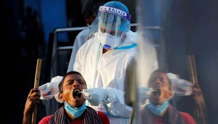 A healthcare worker collects a coronavirus disease (COVID-19) test swab sample from a man, at a temporary shelter for homeless people in New Delhi, India, March 31, 2021. || Photo: REUTERS