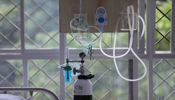 An oxygen cylinder is attached to a ventilator at a hospital bed || Photo: Collected