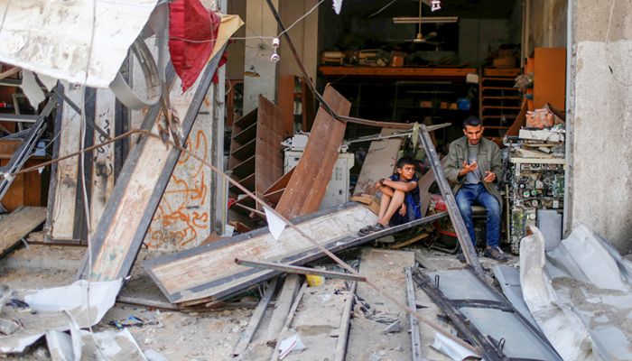 Palestinians sit amidst the damage in the aftermath of Israeli airstrikes, amid Israeli-Palestinian fighting, in Gaza