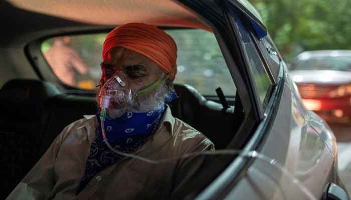 A man with a breathing problem receives oxygen support for free inside his car at a Gurudwara (Sikh temple), amidst the spread of coronavirus disease (COVID-19), in Ghaziabad, India, April 24, 2021. Picture taken April 24, 2021 || Photo: REUTERS