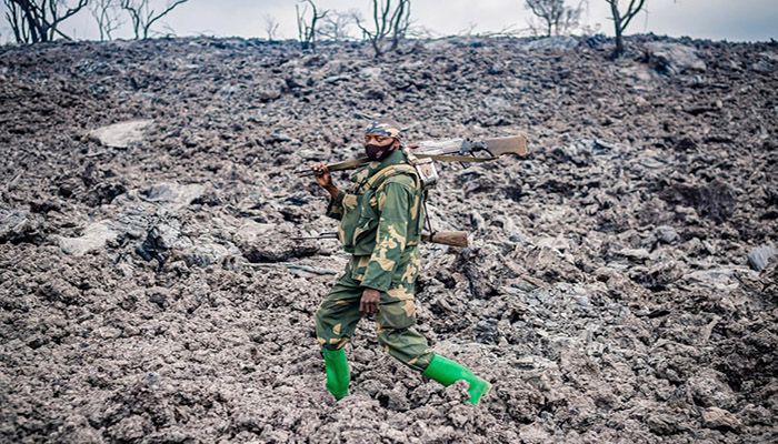 (Goma, Democratic Republic of Congo) A Congolese soldier walks on cooled lava as he provides security for people evacuating from Goma in the aftermath of the eruption of the Nyiragongo volcano. || Photograph: Michel Lunanga/EPA