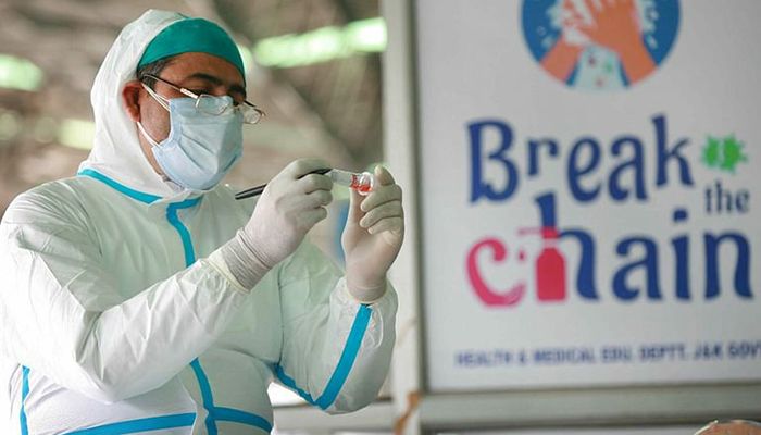A healthcare worker checks the nasal swab taken for COVID-19 testing. || Photo: Collected 