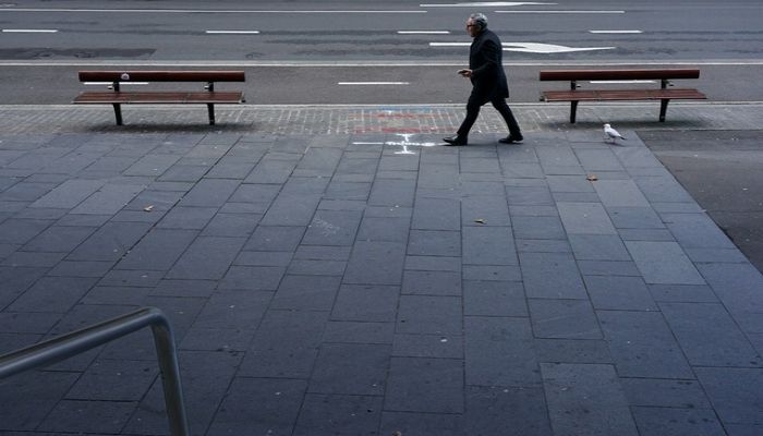 A lone man walks up a deserted street in the city centre during a lockdown to curb the spread of a coronavirus disease (COVID-19) outbreak in Sydney, Australia, July 12, 2021. ||  Photo: REUTERS
