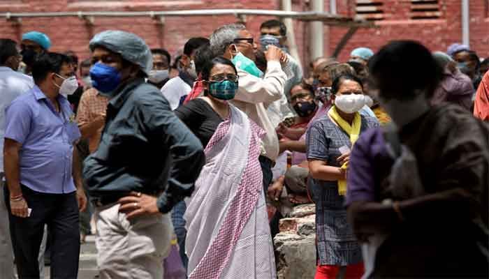 People wearing protective face masks wait to receive their second dose of COVISHIELD, a coronavirus disease vaccine manufactured by Serum Institute of India, outside a vaccination centre in Kolkata, India, May 12, 2021. || Photo: Reuters 