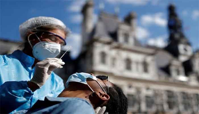 A health worker, wearing a protective suit and a face mask, prepares to administer a nasal swab to a patient at a testing site for the coronavirus disease installed in front of the city hall in Paris, France, September 2, 2020. ||Photo: Reuters