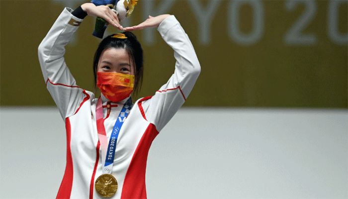 Gold medal winner China's Yang Qian celebrates on the podium after winning the women's 10m air rifle final during the Tokyo 2020 Olympic Games at the Asaka Shooting Range in the Nerima district of Tokyo on July 24, 2021. || AFP Photo: Collected 