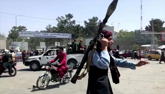 A Taliban fighter runs towards crowd outside Kabul airport, Kabul, Afghanistan August 16, 2021, in this still image taken from a video. || Reuters Photo: Collected