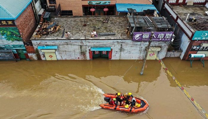 (Henan province, China) Rescue workers evacuate residents from their flooded homes (Photo: AFP)