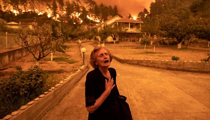 (Evia, Greece) An elderly resident reacts as a wildfire approaches her house in the village of Gouves. Thousands of residents were evacuated by boat after wildfires hit Greece’s second largest island. (Photograph: Konstantinos Tsakalidis/Bloomberg/Getty Images)