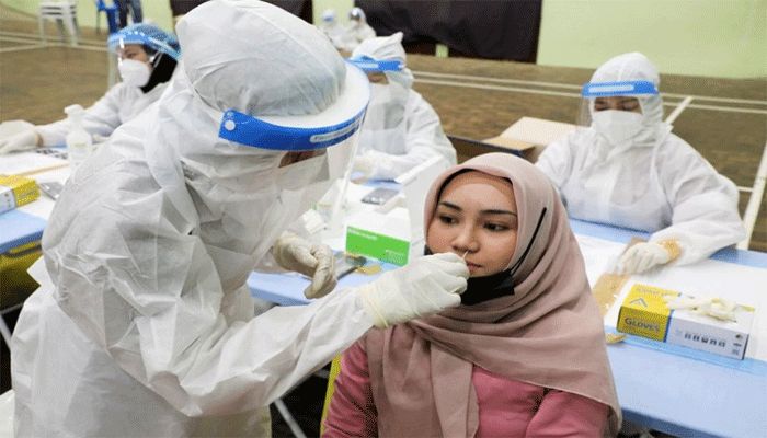A medical worker collects a swab sample from a woman to be tested for Covid-19 in Kuala Lumpur, Malaysia, May 11, 2021. || Reuters Photo: Collected