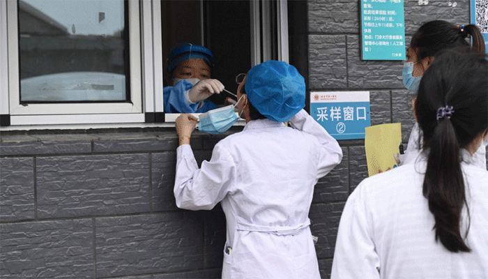 A health worker takes a swab sample from a medical worker to be tested for Covid-19 coronavirus at a hospital in Beijing, China, Aug. 3, 2021. || AFP Photo: Collected  