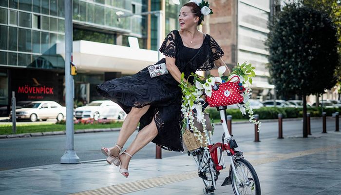 (Izmir, Turkey) A woman dismounts from her bicycle during the women themed World Car Free Day. The event was held to draw attention to the World Car Free Day Fancy Women Bike Ride. || Photograph: Uygar Ozel/ZUMA