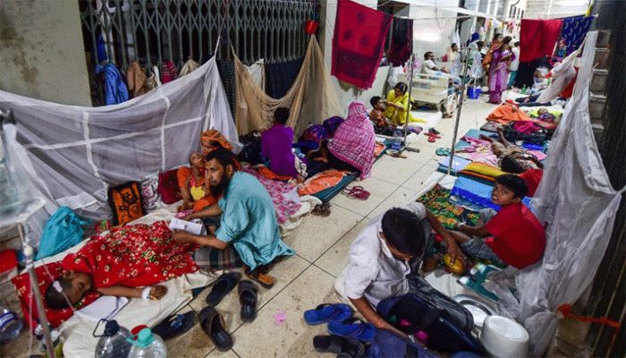 Children suffering from dengue fever and their relatives as they receive treatment in beds on the floor of a ward at the Shaheed Suhrawardy Medical College and Hospital in Dhaka, on August 4, 2019. || AFP Photo: Collected