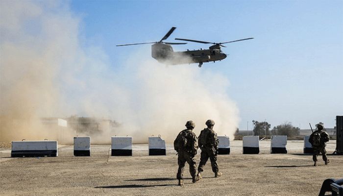 US troops patrol as a US Army C-47 Chinook helicopter flies over the village of Oreij, south of Mosul where a temporary military base has been established for an assault on the city's west bank. || AFP Photo: Collected 