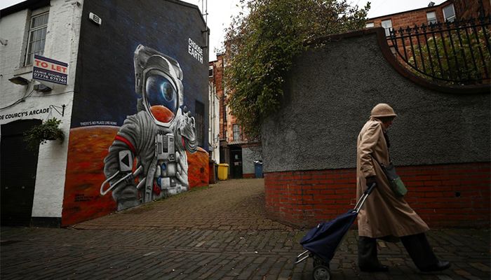 Glasgow, Scotland || A woman walks past the ‘Choose Earth’ mural as the Cop26 UN climate change conference takes place in Glasgow || Photograph: Hannah McKay/Reuters
