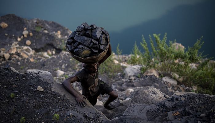 Dhanbad, India || A man climbs a steep ridge with a basket of coal scavenged from a mine in the state of Jharkhand. A government study found that Jharkhand, among the poorest states in India and with the nation’s largest coal reserves, is also one of the areas most vulnerable to climate change. || Photograph: Altaf Qadri/AP 