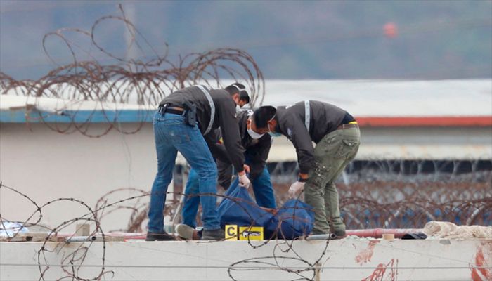 Members of the Ecuadorian police remove the body of an inmate on the roof of a pavilion of the Guayas 1 prison in Guayaquil, Ecuador, on November 13, 2021. || AFP Photo: Collected  