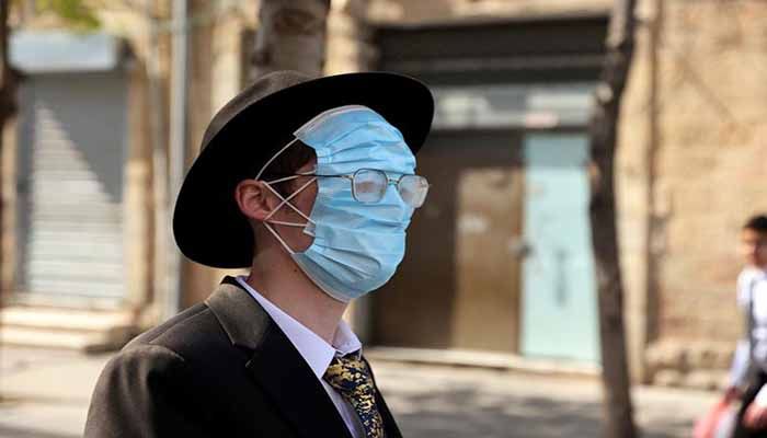 An Ultra Orthodox man wears three masks over his face while celebrating Purim in Jerusalem, February 28. || Photo: REUTERS