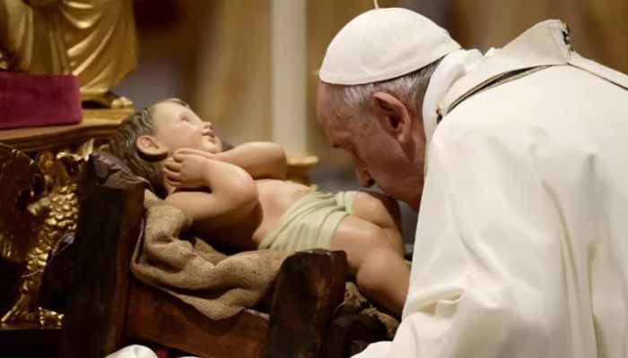 Pope Francis kisses a figurine of baby Jesus during the Christmas Eve mass at St Peter's Basilica in the Vatican, on December 24, 2021. || AFP Photo: Collected 