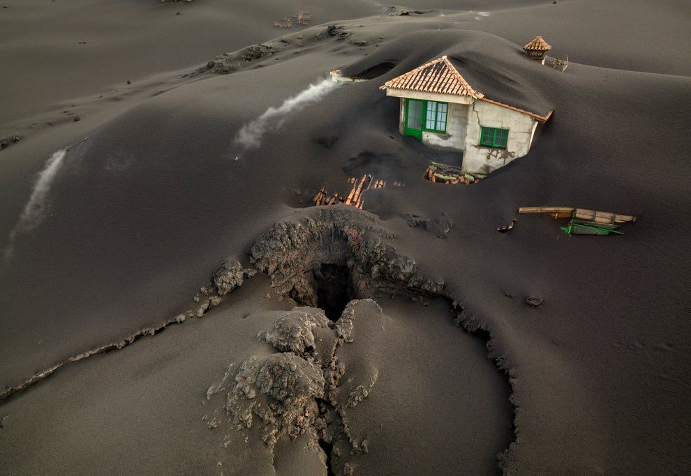 1st December 2021 || A fissure is seen next to a house covered with ash on the Canary island of La Palma, Spain || Emilio Morenatti/AP