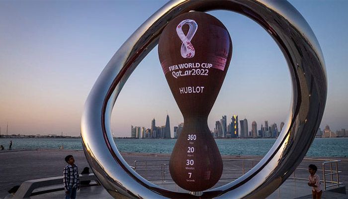 Children stand next to the official countdown clock showing remaining time until the kickoff of the World Cup 2022, in Doha, Qatar, Nov. 25, 2021 || AP Photo