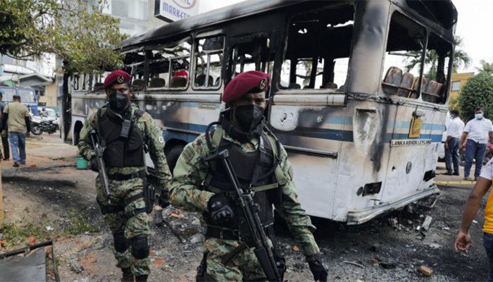 Sri Lankan army commandos walk past a damaged bus after it was set on fire by demonstrators at the top of the road to Sri Lankan President Gotabaya Rajapaksa's residence during a protest against him, as many parts of the crisis-hit country face up to 13 hours without electricity due to a shortage of foreign currency to import fuel, in Colombo, Sri Lanka April 1, 2022 || Photo: REUTERS/Dinuka Liyanawatte