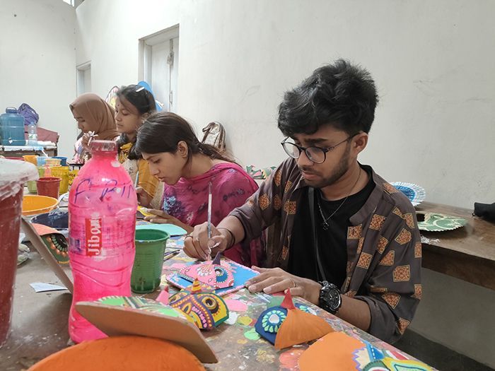 As the procession was suspended in the last two years due to the Covid-19 lockdown, students at the Institute of Fine Arts were seen painting masks and other motifs in a joyful spirit in front of the Zainul Gallery to make the Shobhajatra successful this time around.